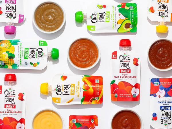 Once Upon a Farm baby food pouches, arranged next to the purees in bowls