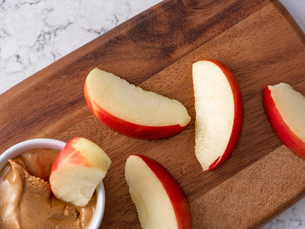apple slices and nut butter on a cutting board