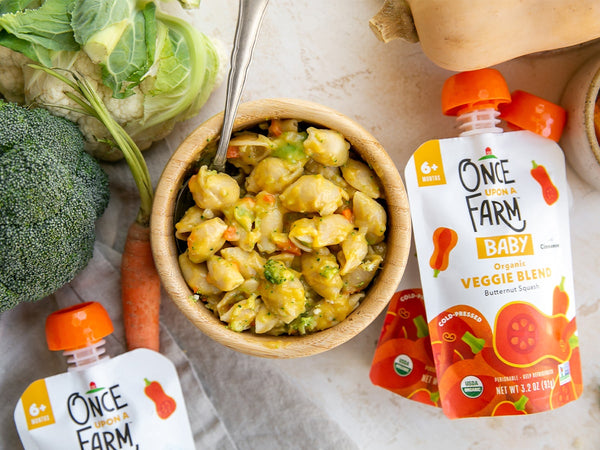 butternut squash mac and cheese in a bowl, surrounded by Once Upon a Farm Butternut Squash Veggie Blend pouches