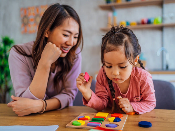 mom helping her child with a learning game
