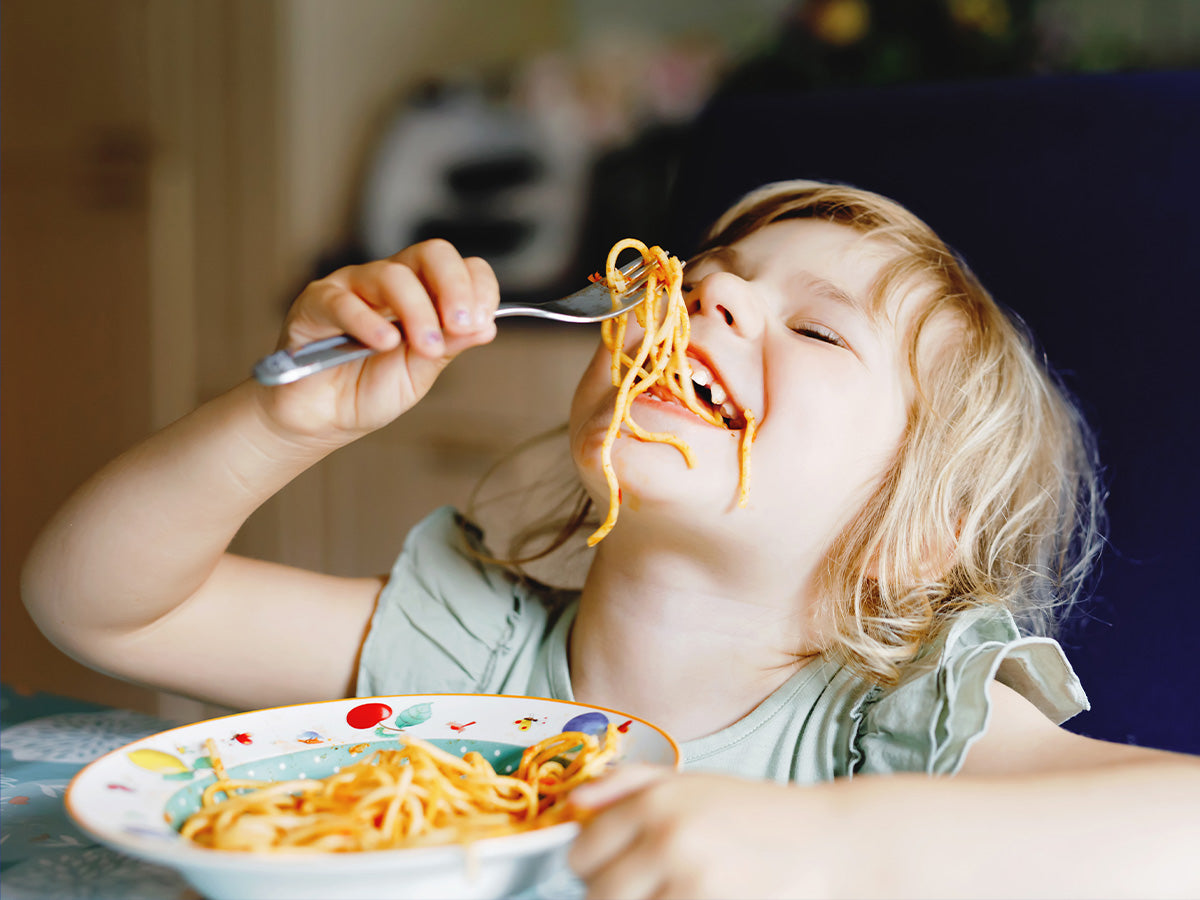 toddler eating spaghetti and being silly