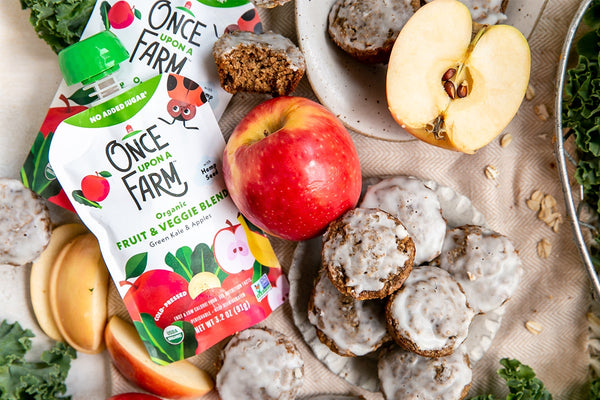 apple donut holes, next to two once upon a farm green kale & apples pouches and two fresh apples