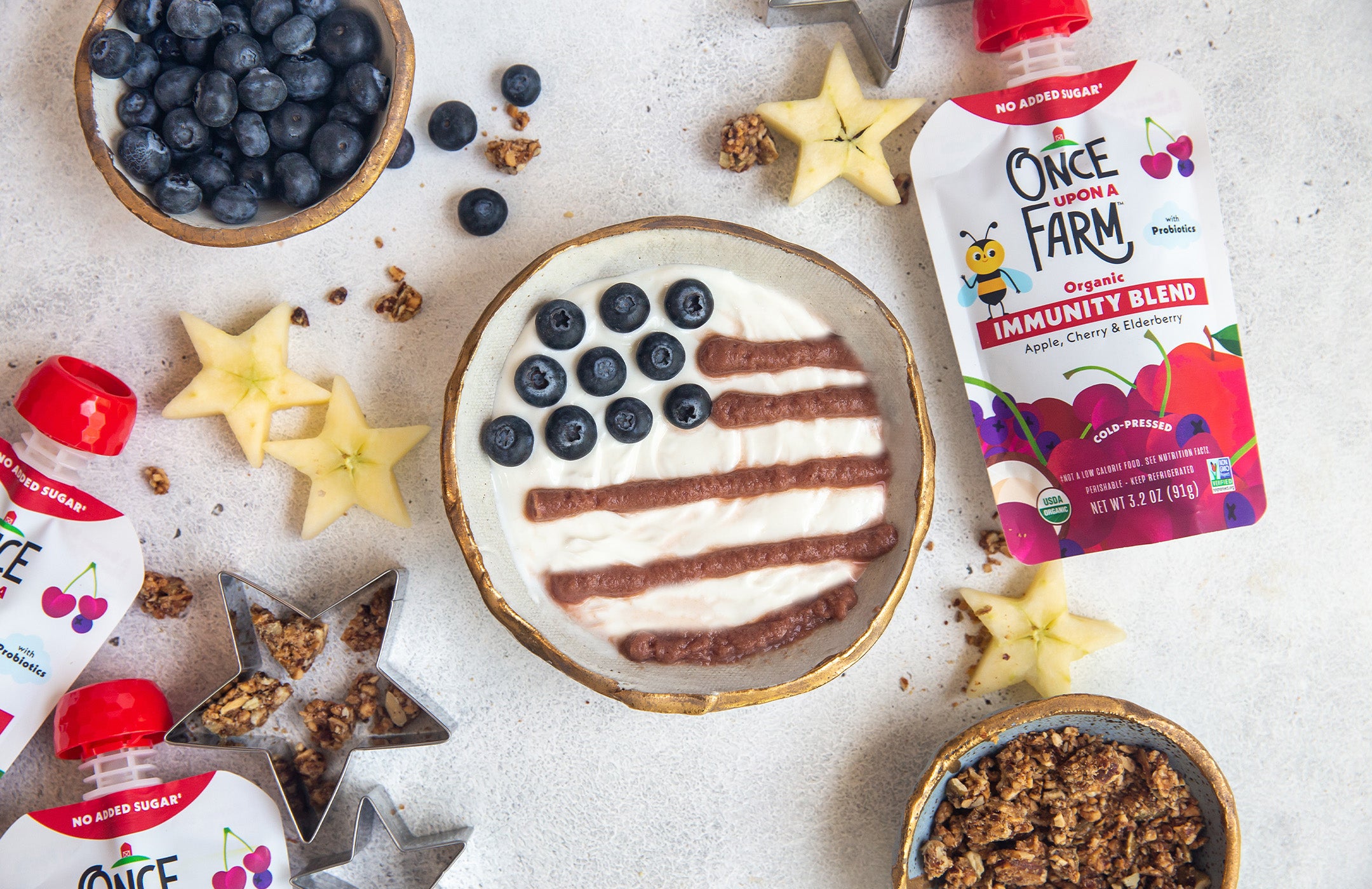 yogurt bowl with Once Upon a Farm Immunity Blend as the stripes and blueberries as the stars for a flag shape