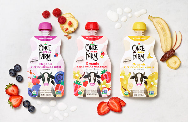 3 Once Upon a Farm A2/A2 Whole Milk Shake pouches, surrounded by fresh fruit