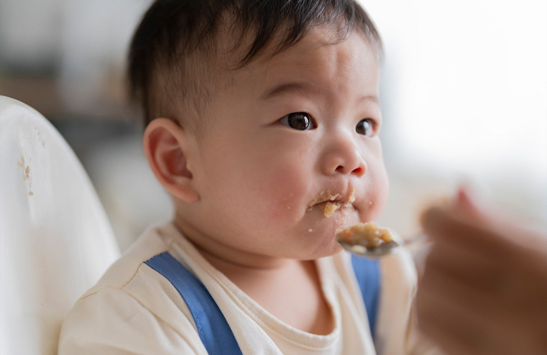 baby being spoon-fed mashed beans