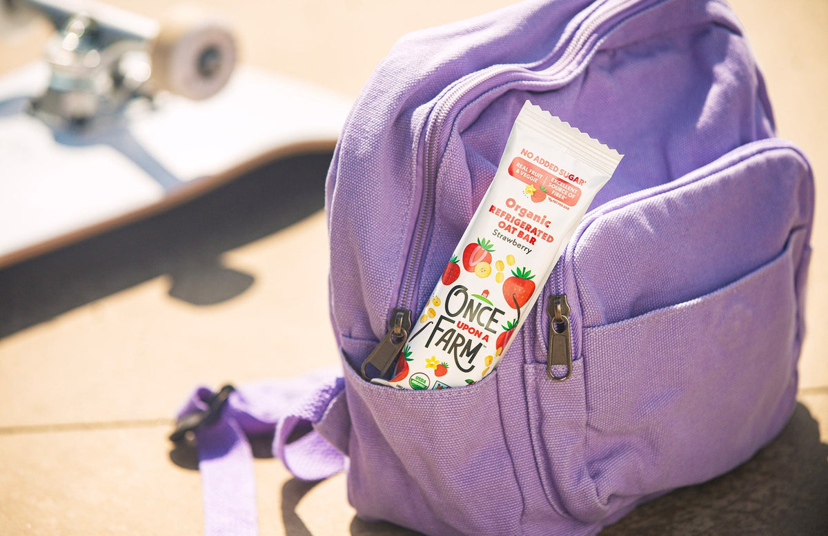 Strawberry Refrigerated Oat Bar sticking out of a purple backpack pocket