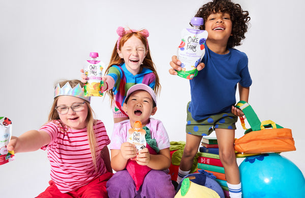 group of kids with Once Upon a Farm pouches, backpacks, and books