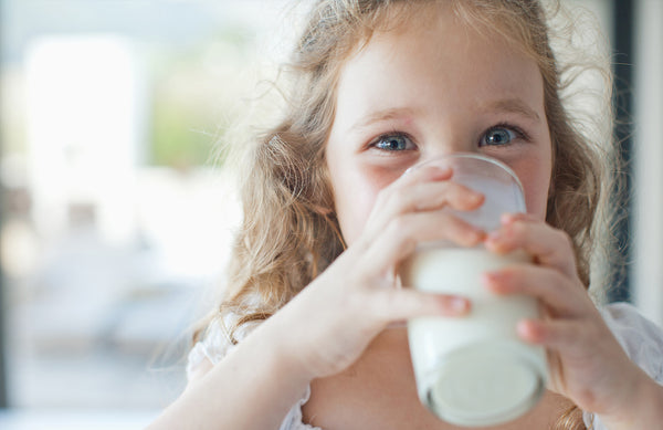 child drinking a glass of milk