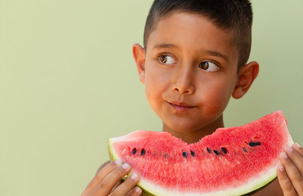 child eating a large slice of watermelon