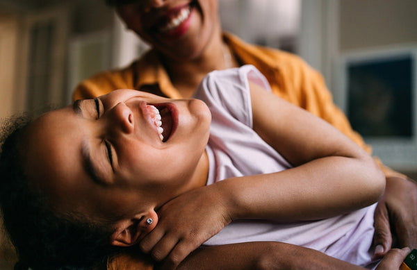 child laughing with mom