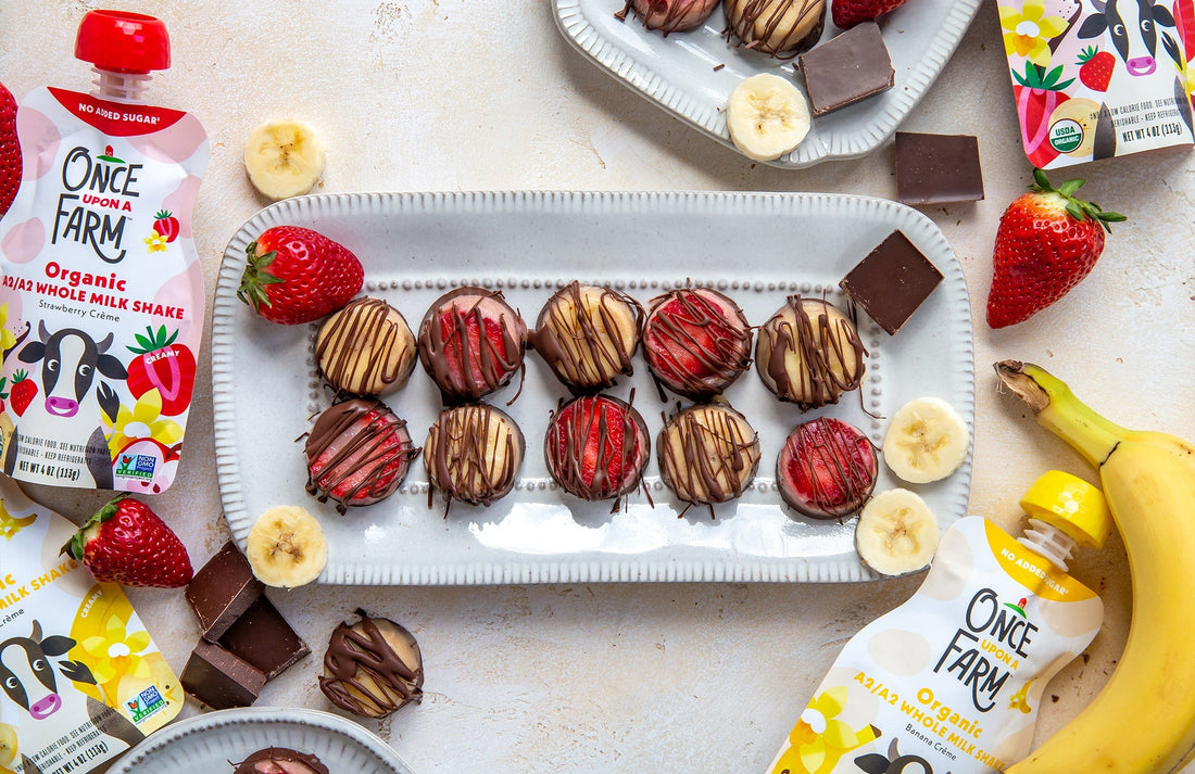 frozen chocolate-covered milkshake bites on a tray, surrounded by Once Upon a Farm pouches, fruit, and chocolate