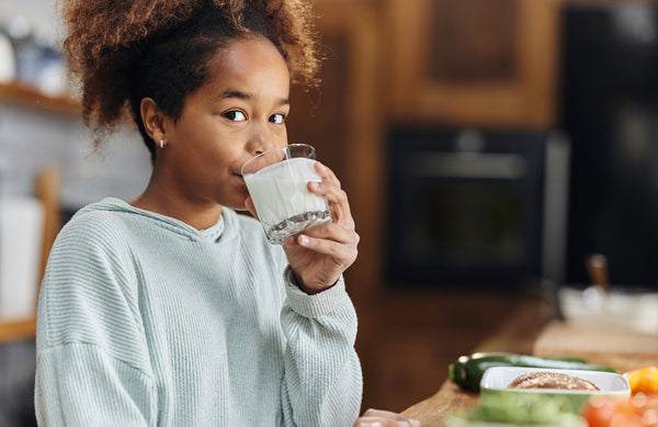 adolescent girl drinking a glass of milk