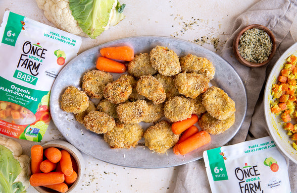 homemade chicken nuggets, made with Once Upon a Farm Carrot, Cauliflower & Hemp Seed Meal. Nuggets are arranged on a plate and surrounded by fresh cauliflower, carrots, hemp seeds, and the Once Upon a Farm packaging
