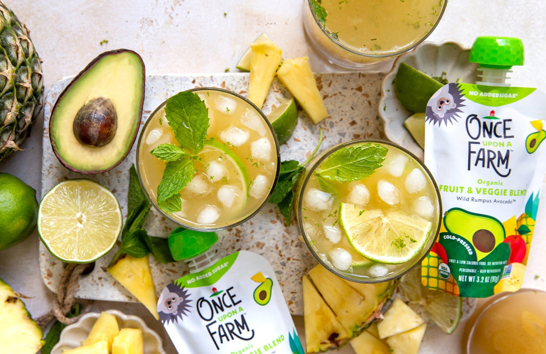 birds-eye view of mocktails on a platter, surrounded by fresh avocado, lime, pineapple, and Once Upon a Farm pouches