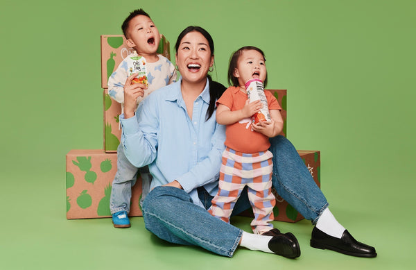 mom and two kids in front of a pile of Once Upon a Farm boxes