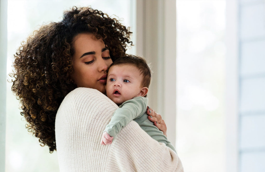 close-up of mom holding a baby and comforting them