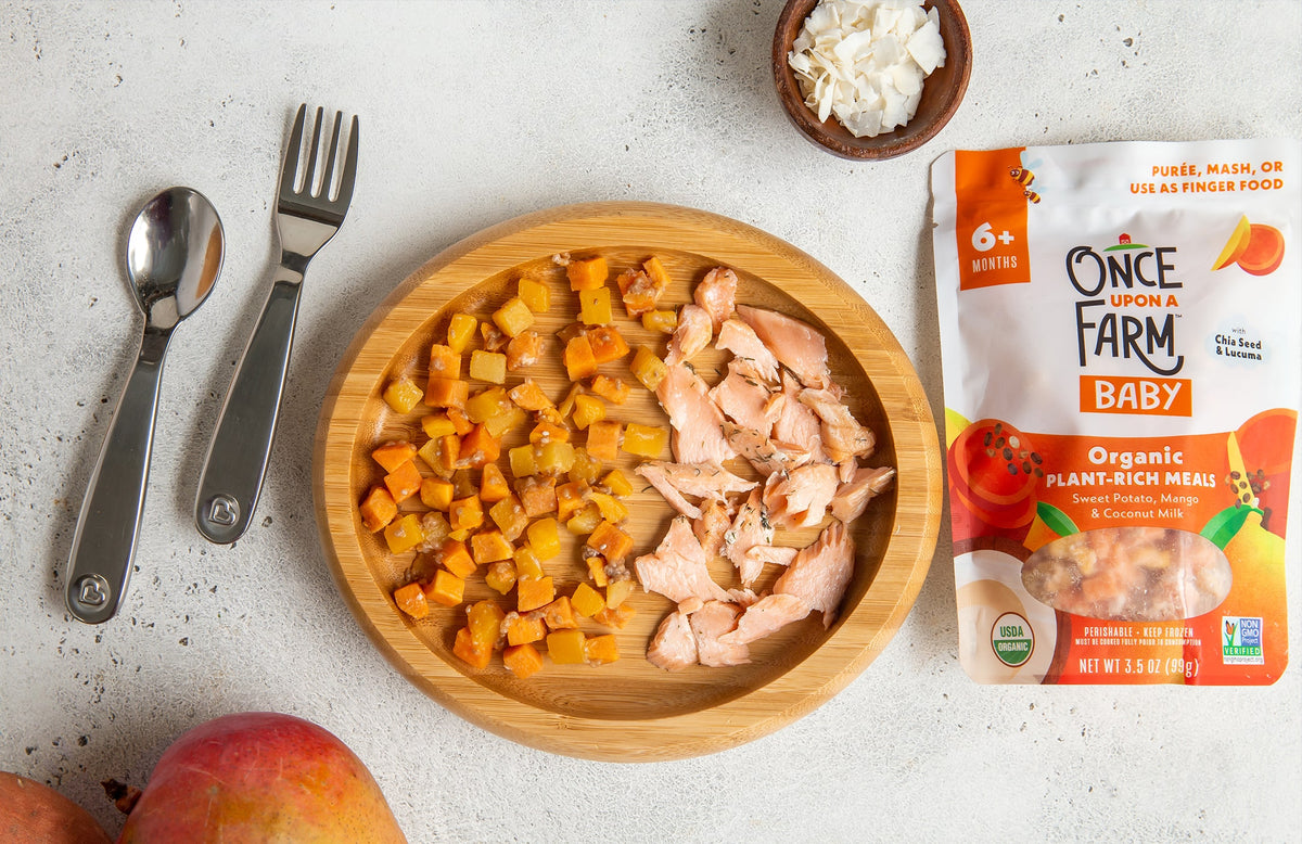 Once Upon a Farm Sweet Potato, Mango & Coconut Milk Plant-Rich Meal, plated with pieces of cooked salmon