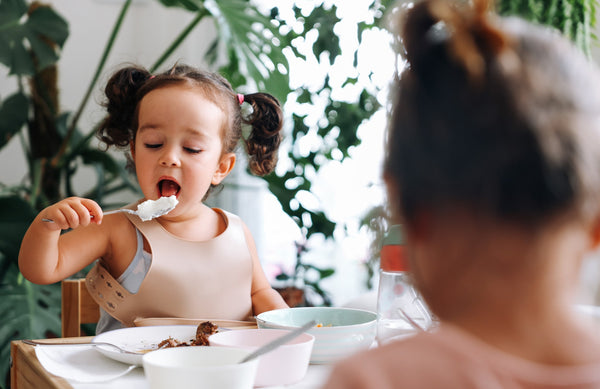 toddler eating yogurt with a spoon
