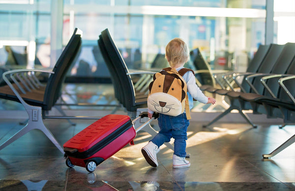 toddler rolling a suitcase through the airport
