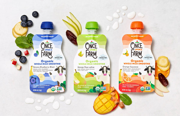 3 flavors of Once Upon a Farm Whole Milk Smoothie pouches, next to fresh fruits and veggies