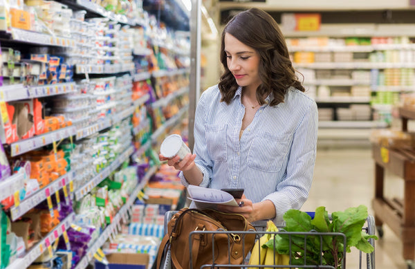 woman reading a product label at the grocery store