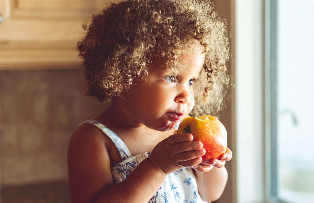 young girl eating an apple