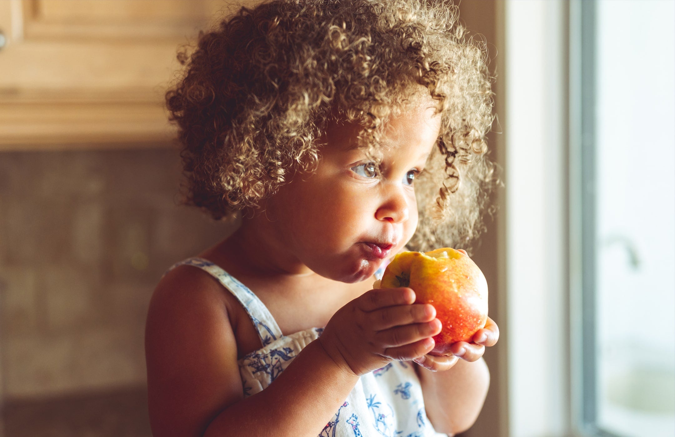young girl eating an apple