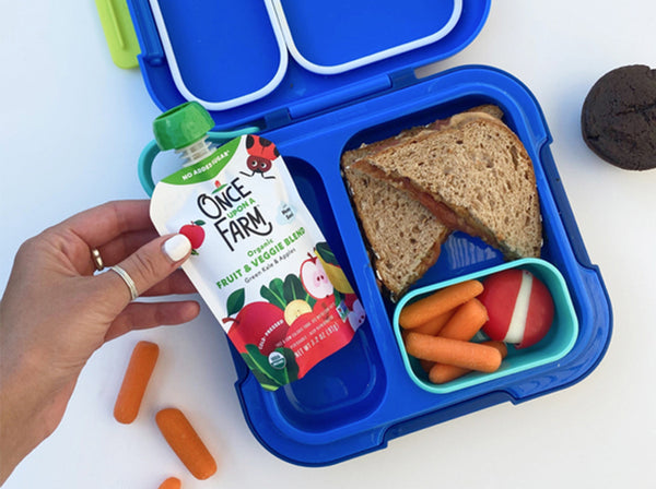 lunchbox with a sandwich, carrots, and a Once Upon a Farm Fruit & Veggie pouch