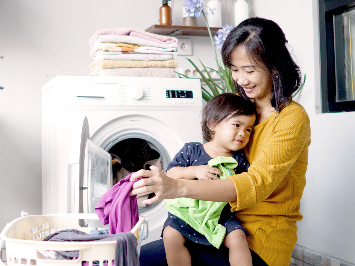 Mother and daughter folding freshly-washed laundry.