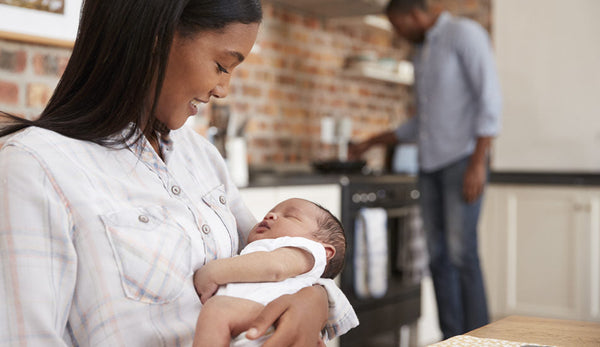 Postpartum mother holding a newborn baby.