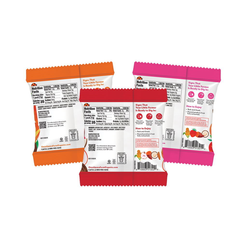 Three packaged snack bags shown from the back on a plain white background, each in a different color: orange, red, and pink. The packaging displays nutrition facts, ingredients, and how-to graphics.